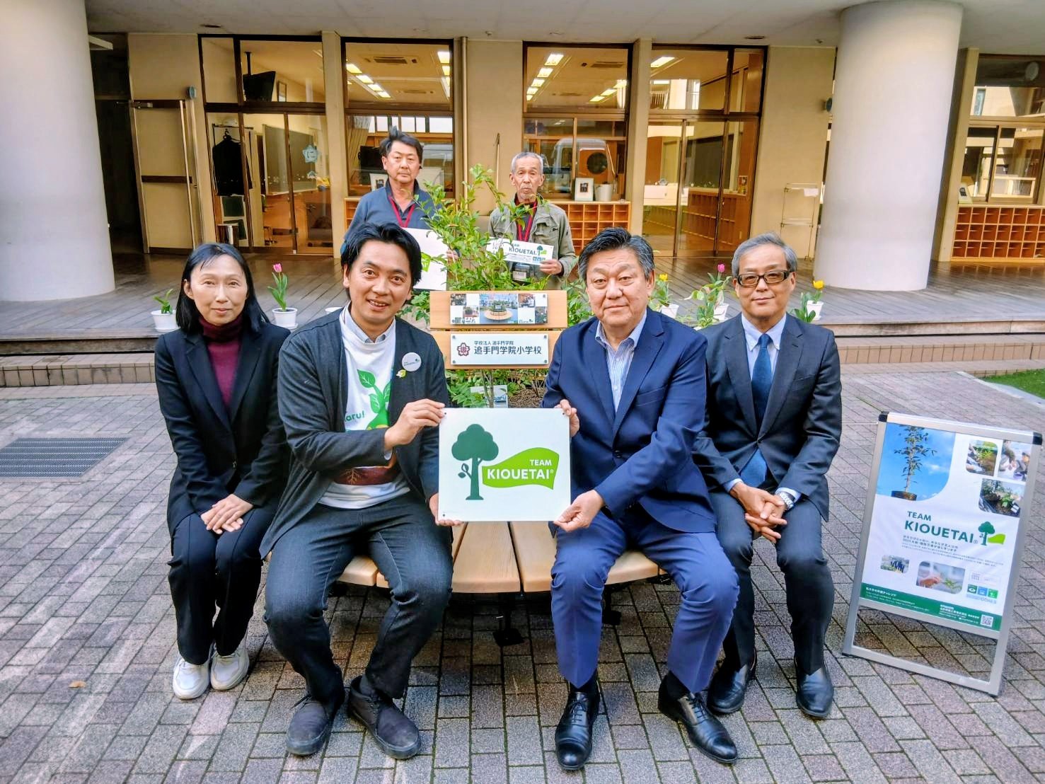 植えた苗木とプレートを手にする参加者